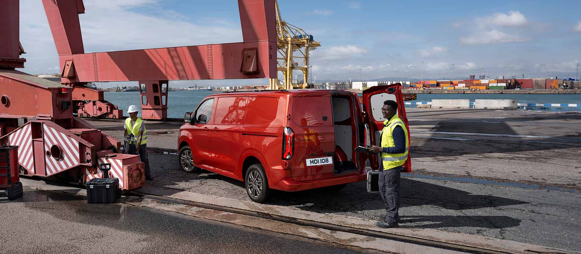 Een rode Ford Transit Custom bestelwagen bij een dok.