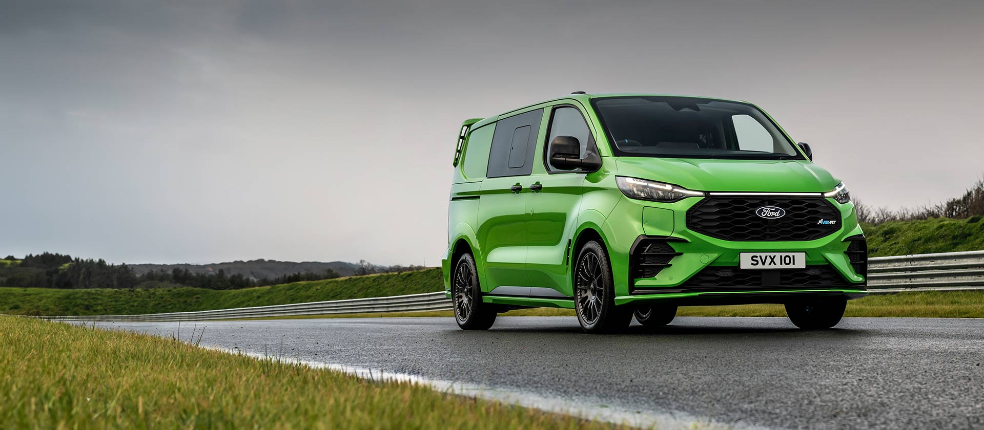 Een groene Ford Transit Custom MS-RT rijdt op een circuit.
