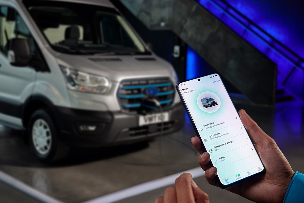 Persoon met een mobiele telefoon waarop Ford Pro-voertuiggegevens worden weergegeven
