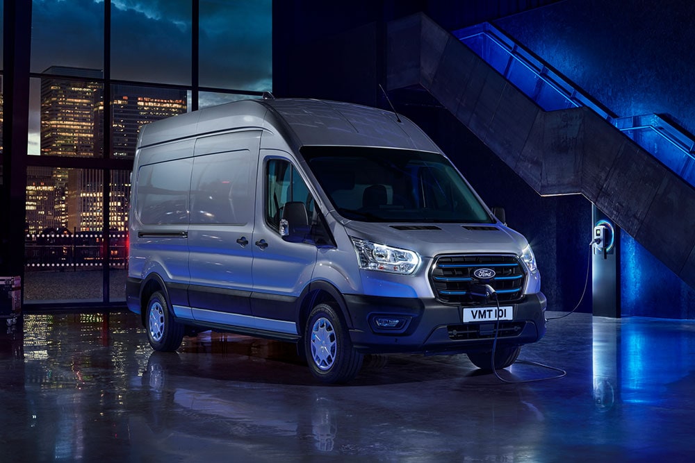 Ford E-Transit bestelwagen geparkeerd bij een laadpaal van een bedrijf.