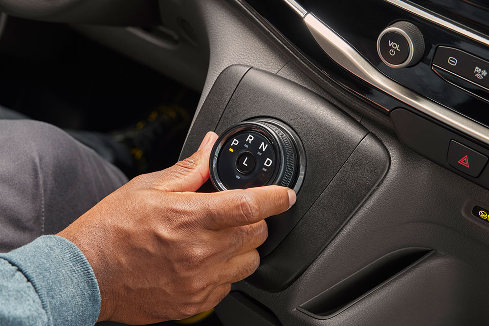 Close-up van een hand die aan de schakelknop in een Ford E-Transit elektrische bestelwagen draait.