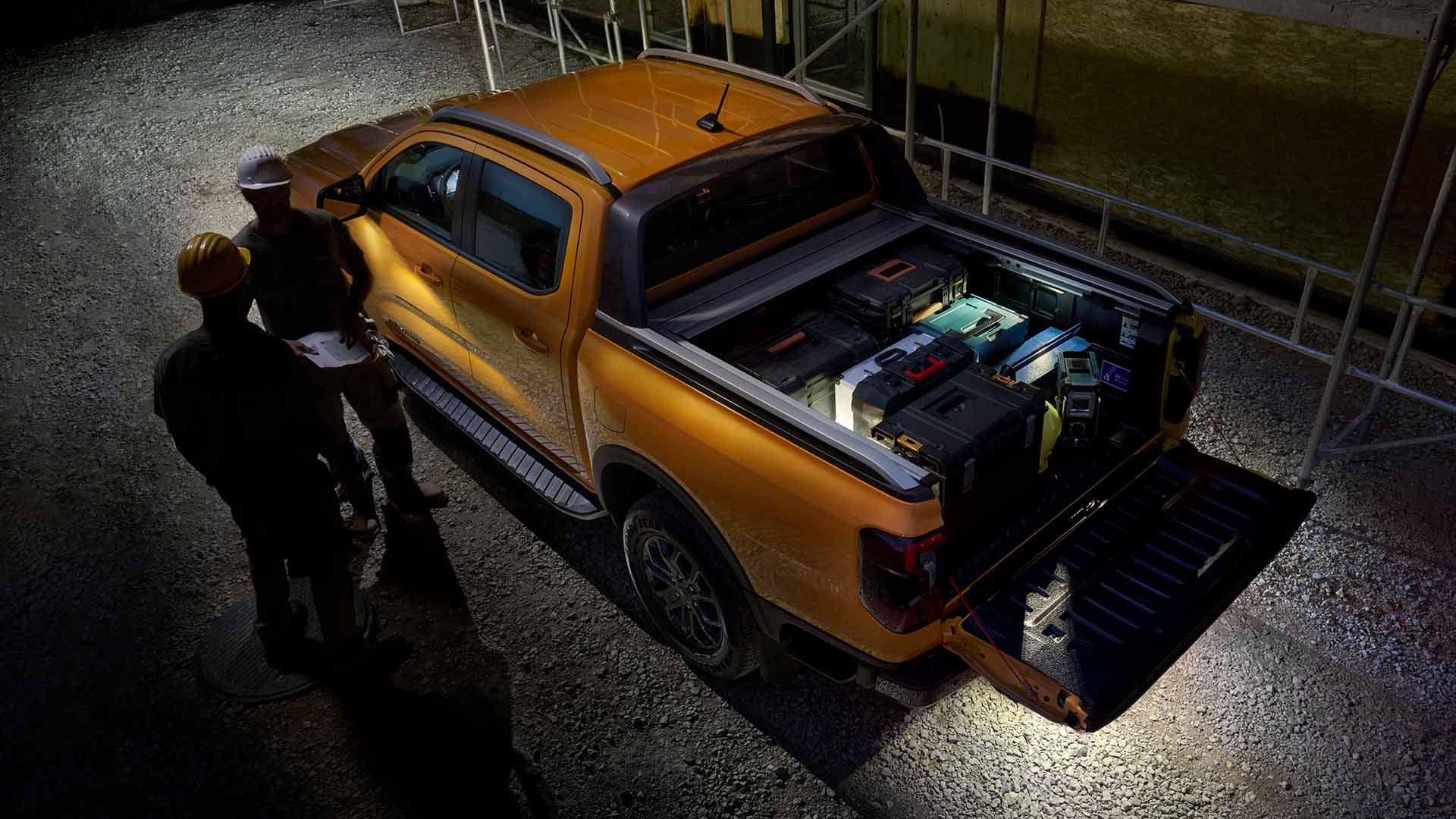 Bovenaanzicht van de gele Ford Ranger Wildtrak bij nacht met zoneverlichting.