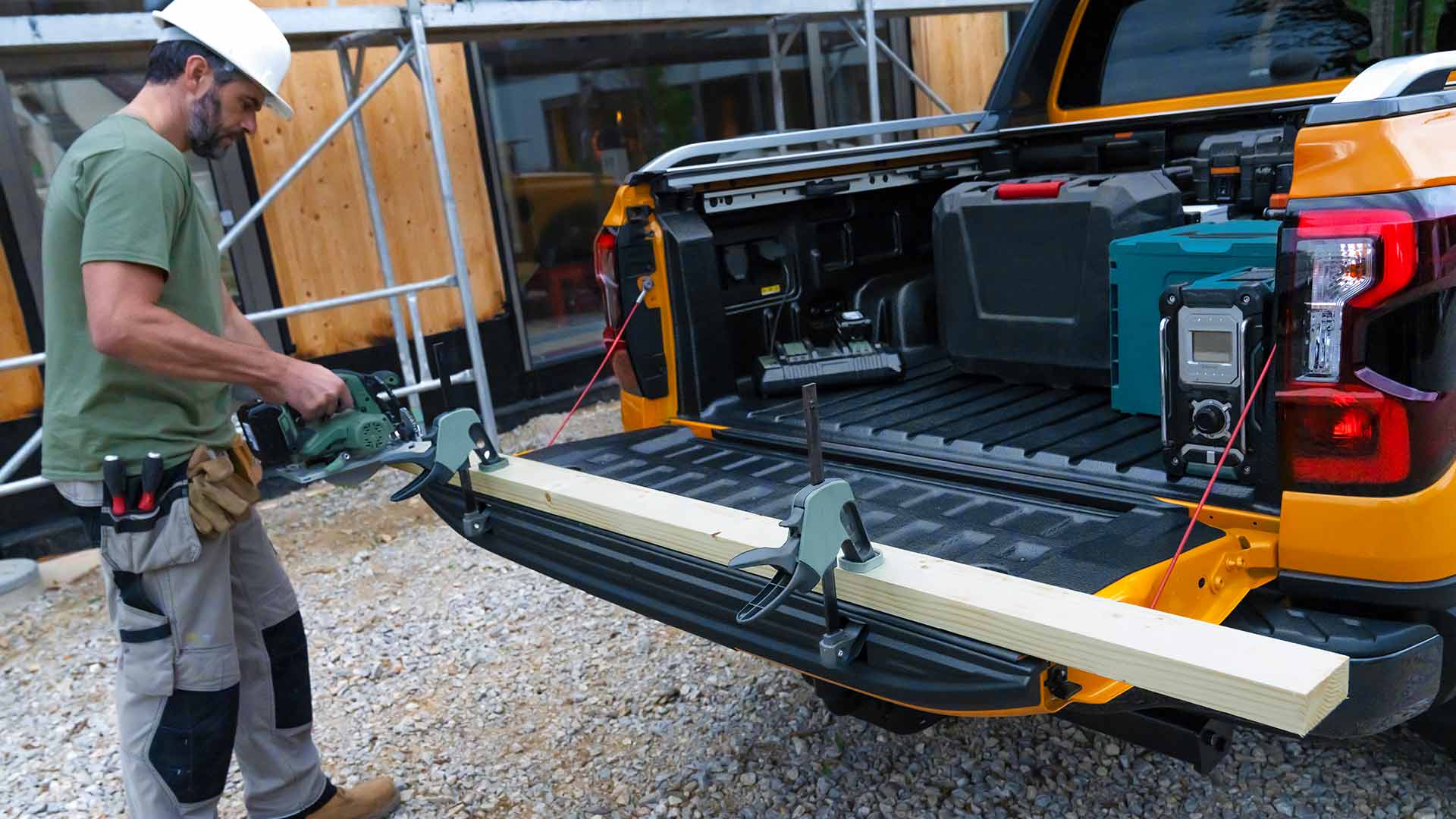 Werknemer die de achterklep van de Ford Ranger Wildtrak als werkbank gebruikt.