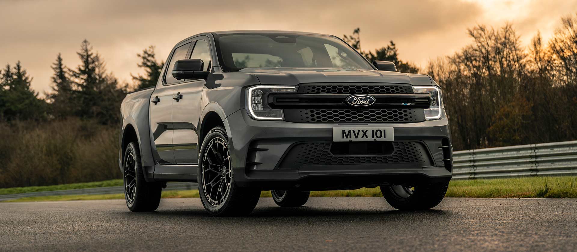 Driekwart vooraanzicht van een Ford Ranger MS-RT op een circuit in vervagend zonlicht.