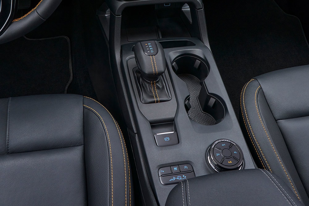 Middenconsole van de Ranger met automatische versnellingsbak, draaiknop voor de rijmodus en bekerhouders.