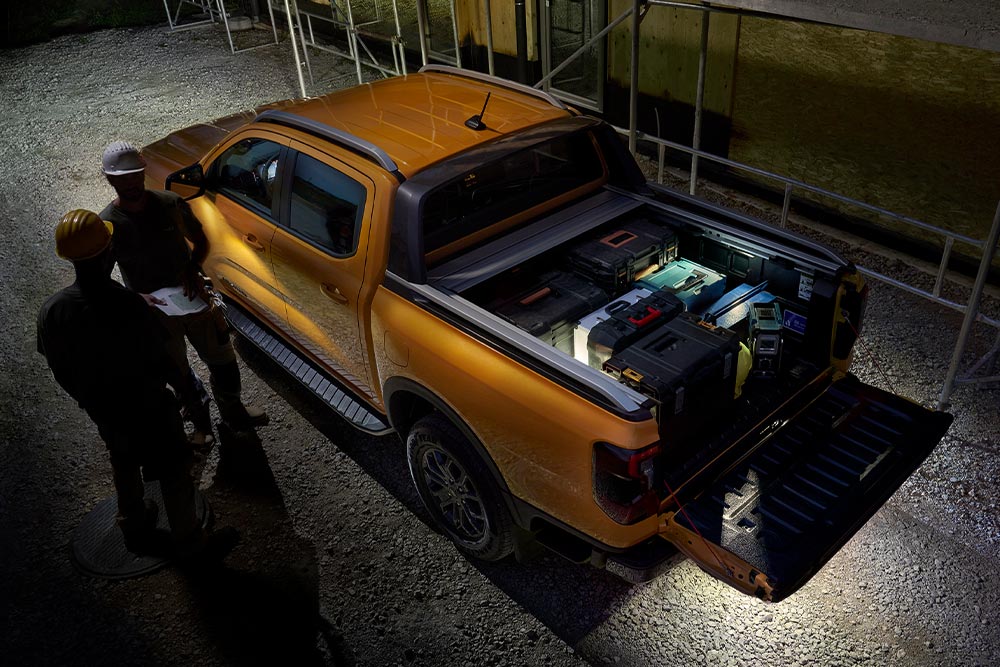 Bovenaanzicht van de gele Ford Ranger Wildtrak in het donker met zoneverlichting aan de buitenkant.