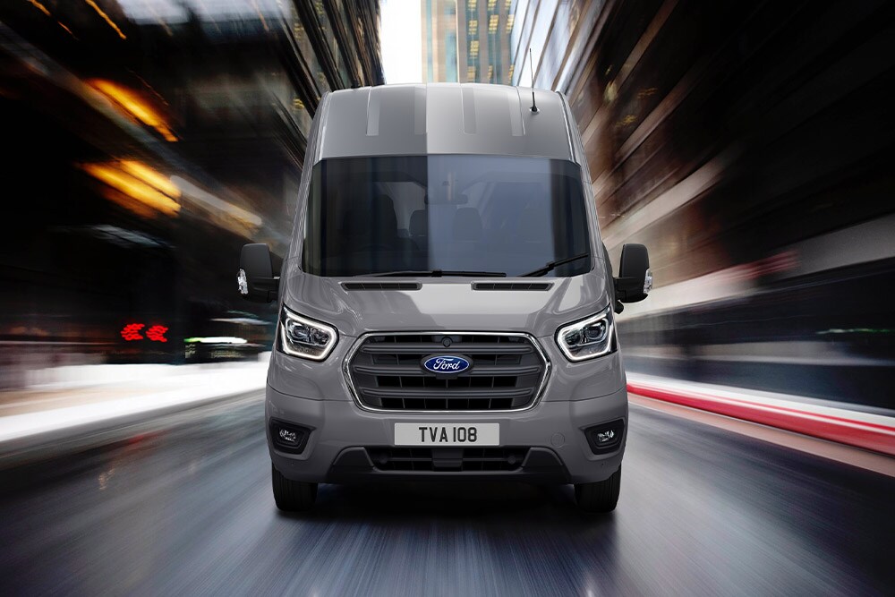 Vooraanzicht van een Ford Transit bestelwagen rijdend in de stad.