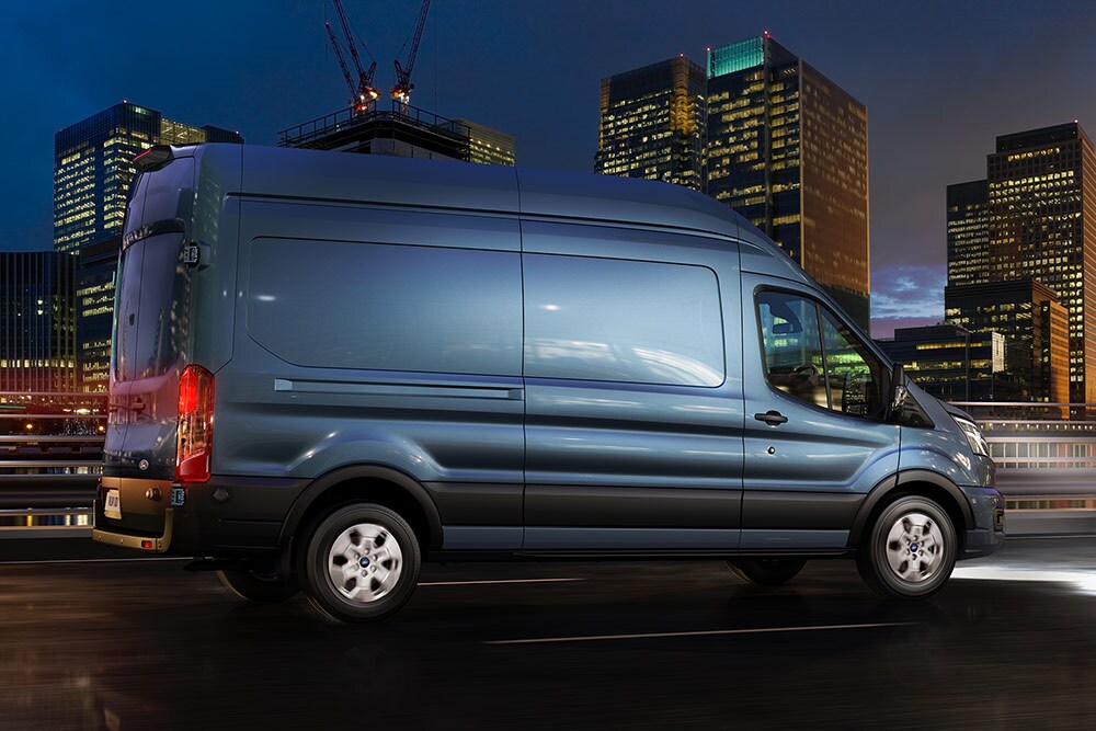 Ford Transit bestelwagen rijdt in het donker in de stad.