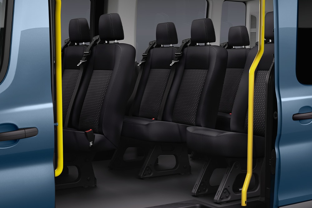 Zicht op de Ford Transit Kombi passagierszetels via de schuifdeur aan de zijkant.