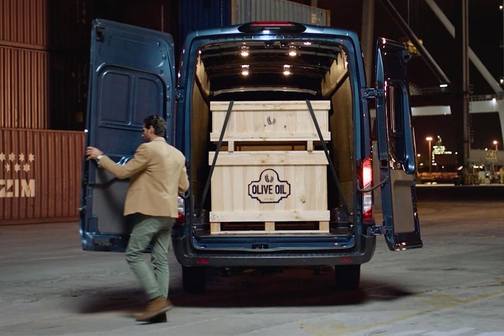 Ford Transit bestelwagen met open achterdeuren en lading binnenin.