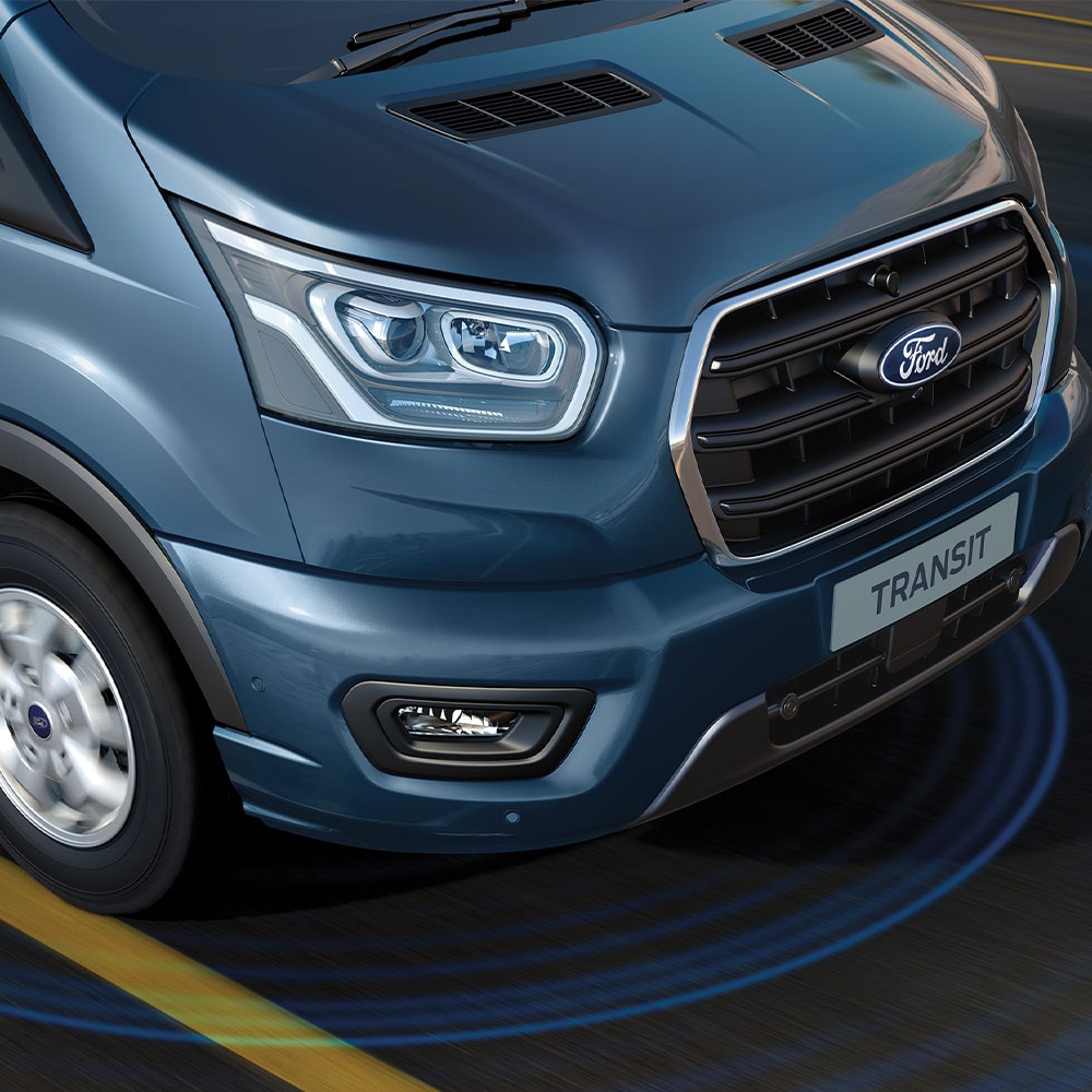 Blauwe Ford Transit bestelwagen met blauwe lijnen op de weg die het gebruik van geavanceerde rijhulpsystemen weergeven.