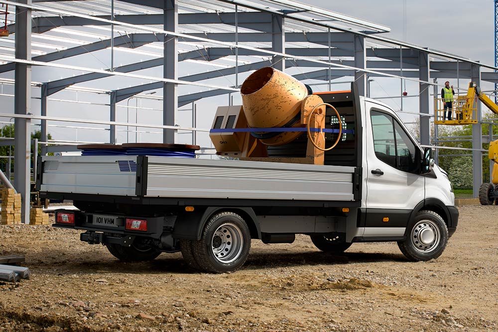 Ford Transit Chassis Cab met een cementmixer in het laadbed geparkeerd op een bouwplaats. 