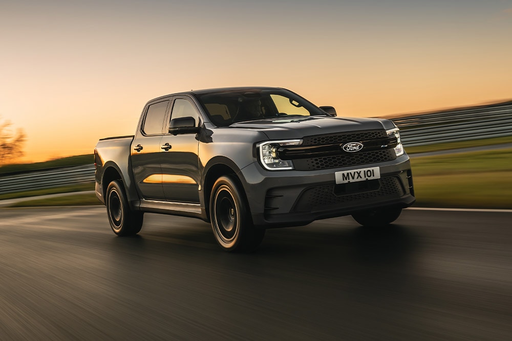 Een donkergrijze Ford Ranger Platinum bij zonsondergang op een circuit.