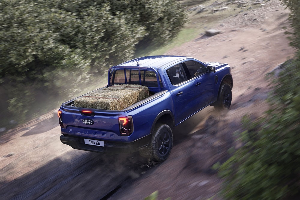 Bovenaanzicht van een blauwe Ford Ranger op een onverharde weg.