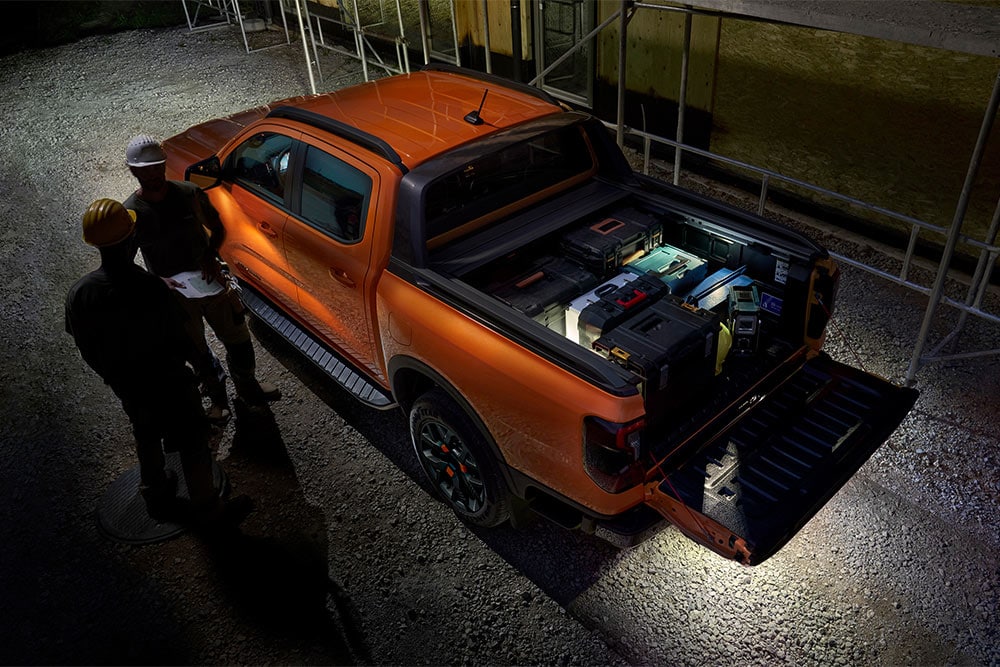 Bovenaanzicht van de oranje Ford Ranger Wildtrak in het donker met zoneverlichting aan de buitenkant.