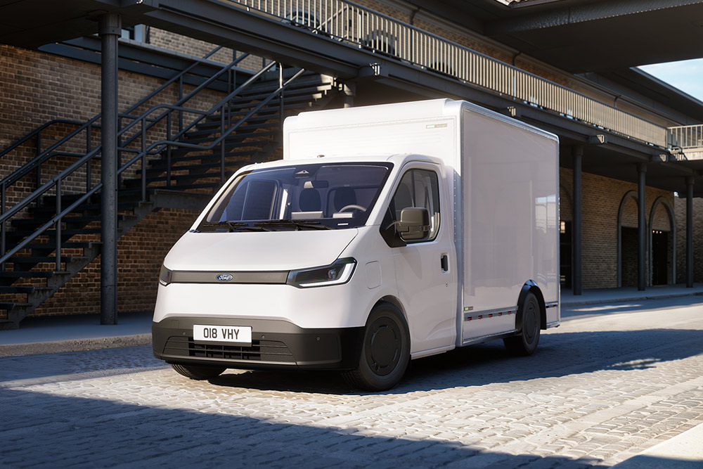 Witte Ford Transit City® Chassis Cab-bestelwagen geparkeerd voor een bakstenen gebouw.