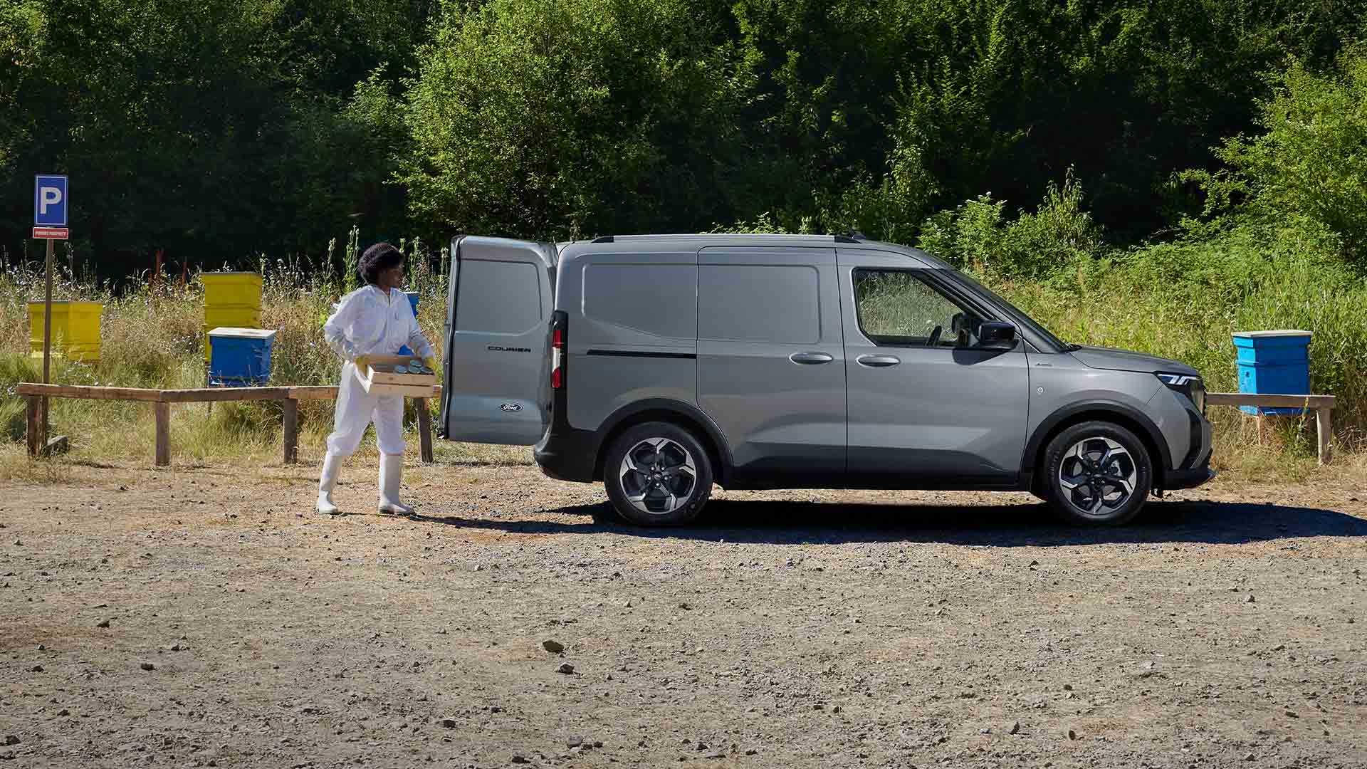 Imker die honing inlaadt in een Ford Transit Courier.