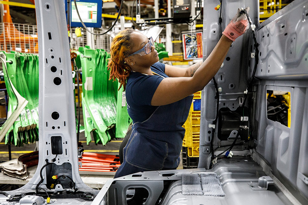 Ford-monteur werkt aan een bestelwagen in een garage.