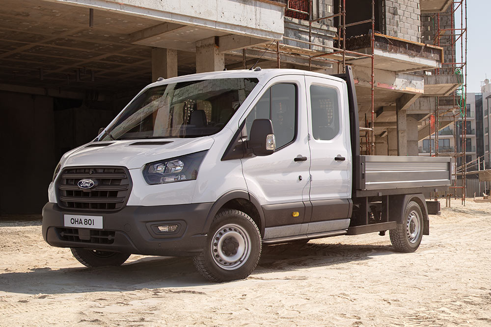 Witte Ford Pro Chassis Cab geparkeerd op een bouwplaats naast twee bouwvakkers.