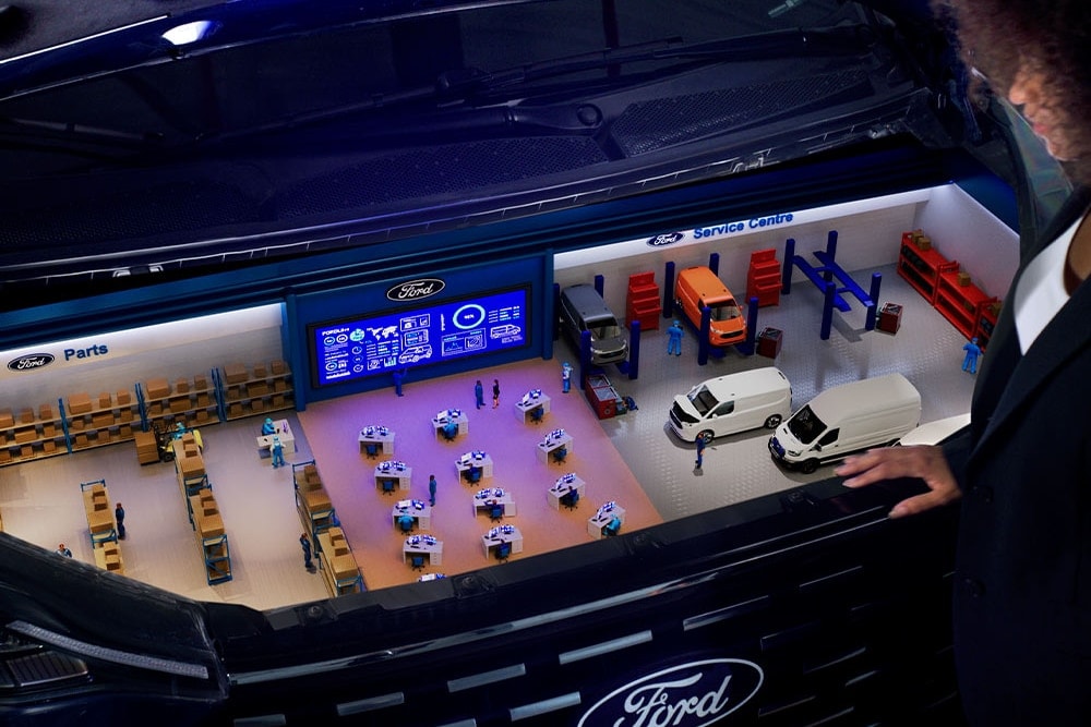 Miniatuurmodel van een Ford servicecentrum in een kofferbak.