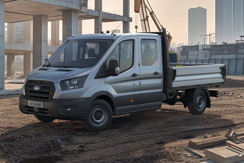 Een wit Ford E-Transit chassis-cabine voertuig geparkeerd op een bouwplaats.