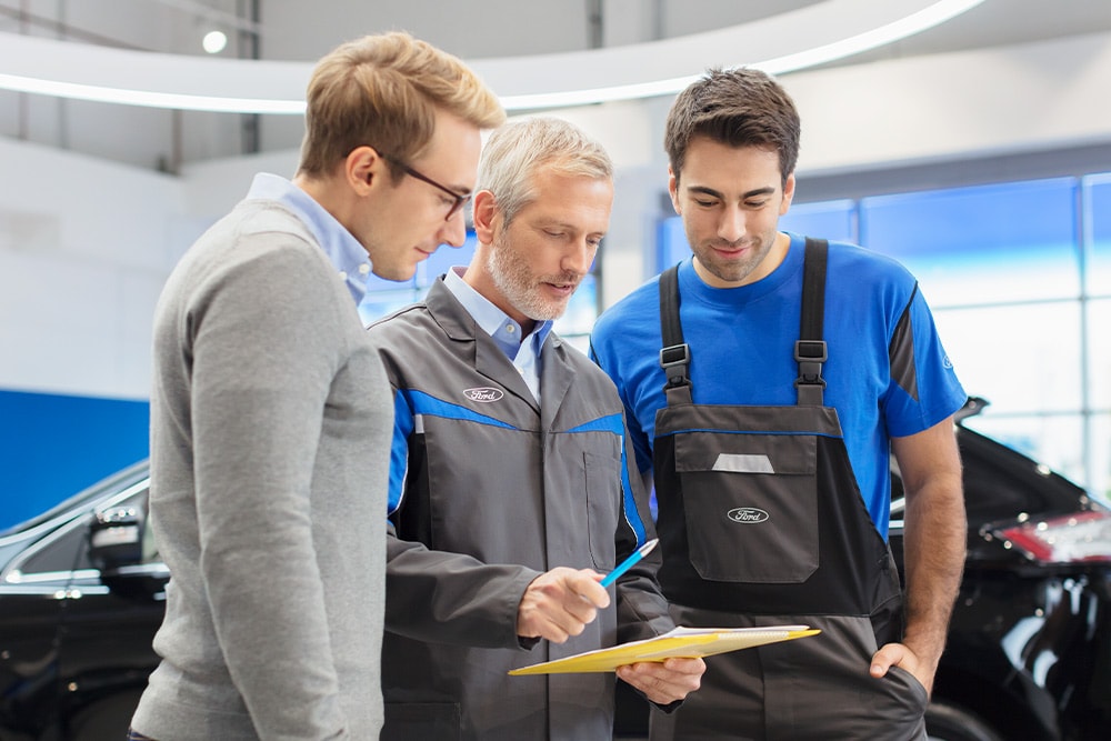 Drie experts bespreken kant-en-klare voertuigopties in een Ford Transit Centre.