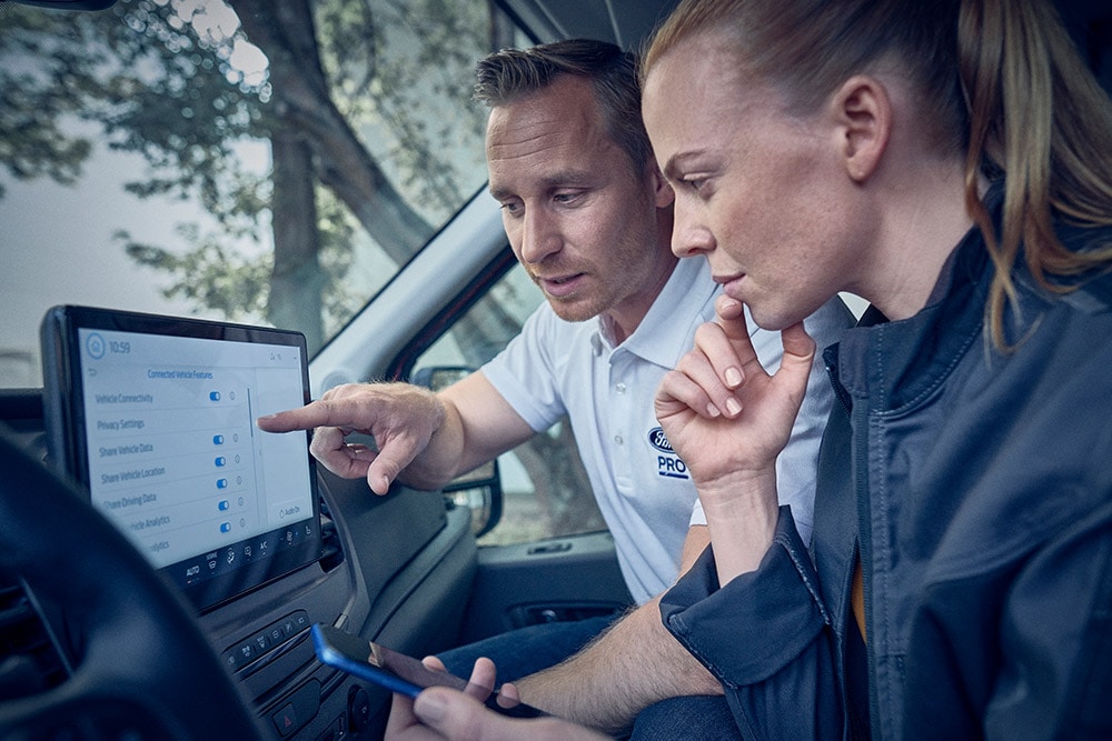  Verschillende elektrische Ford bedrijfsvoertuigen geparkeerd voor een magazijn.