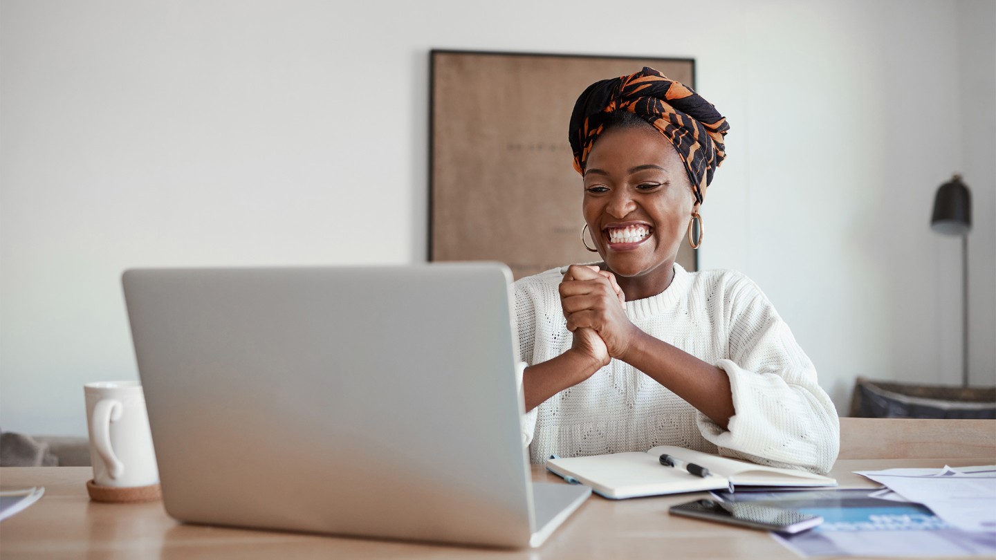 Vrouw lacht en kijkt naar laptop
