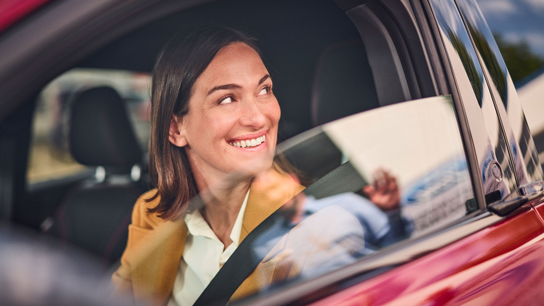 Lachende dame in een rode Ford.