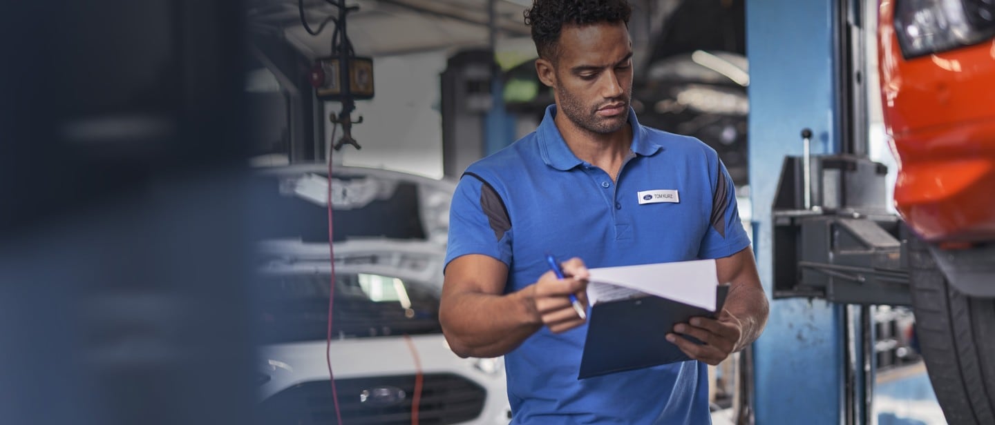 Ford technician inspecting a vehicle