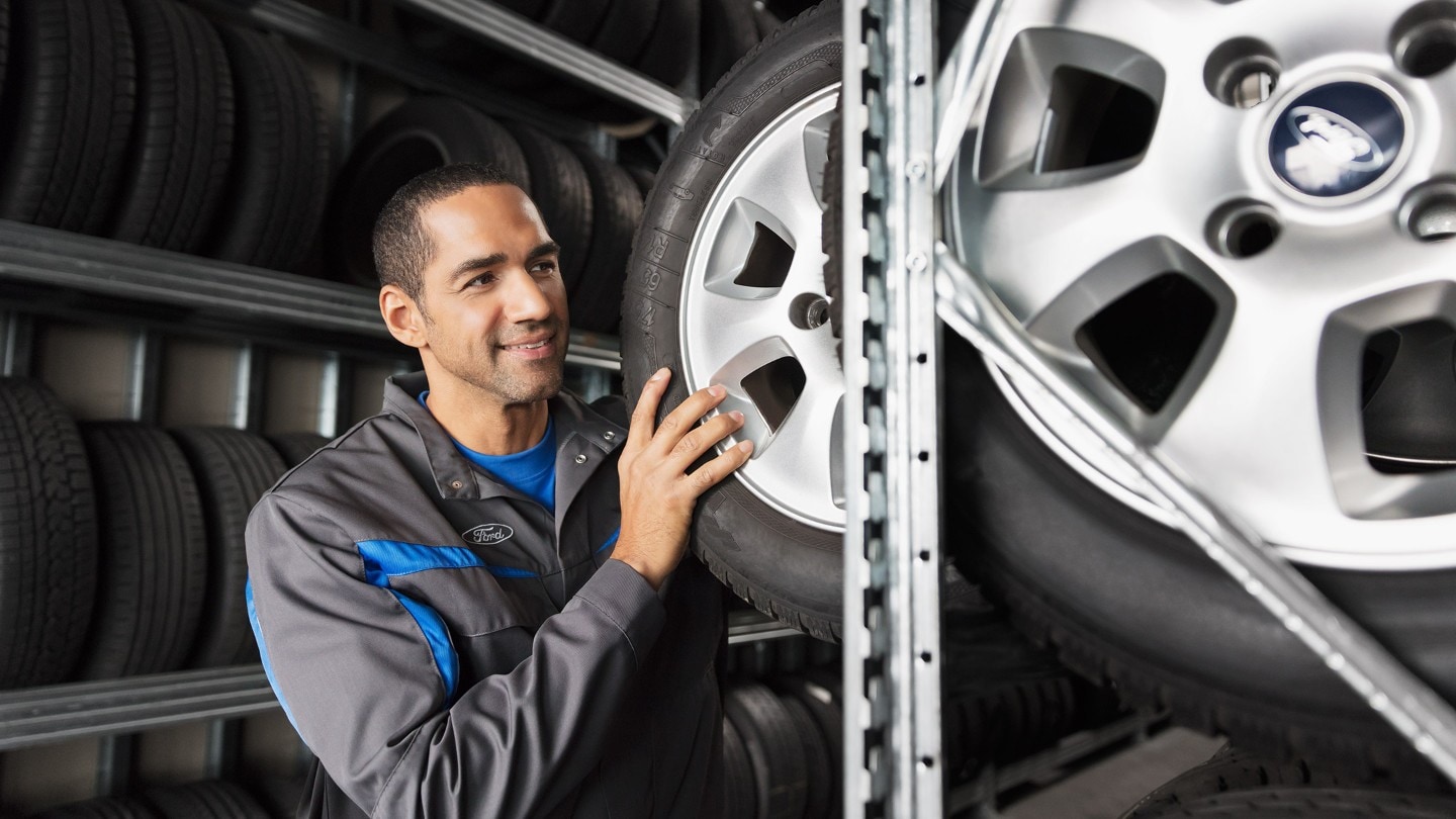 Ford mechanic holding a tyre